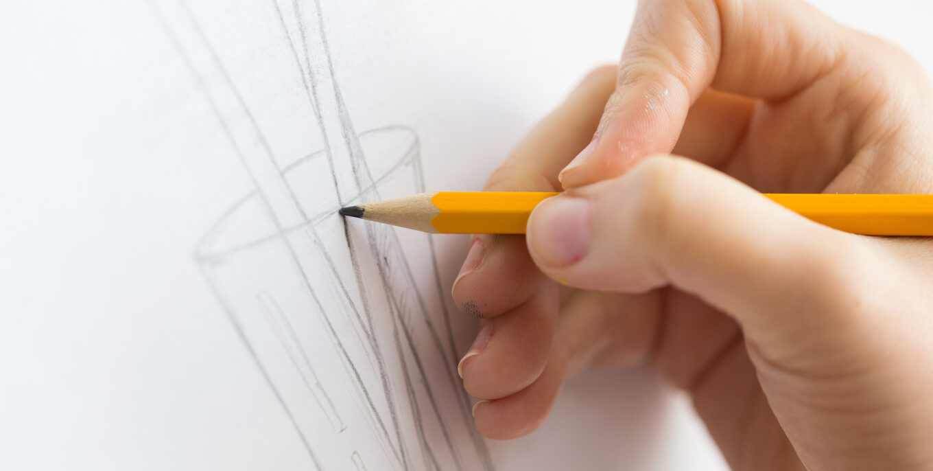 Bleistift skizziert eine geometrische Form auf Papier.