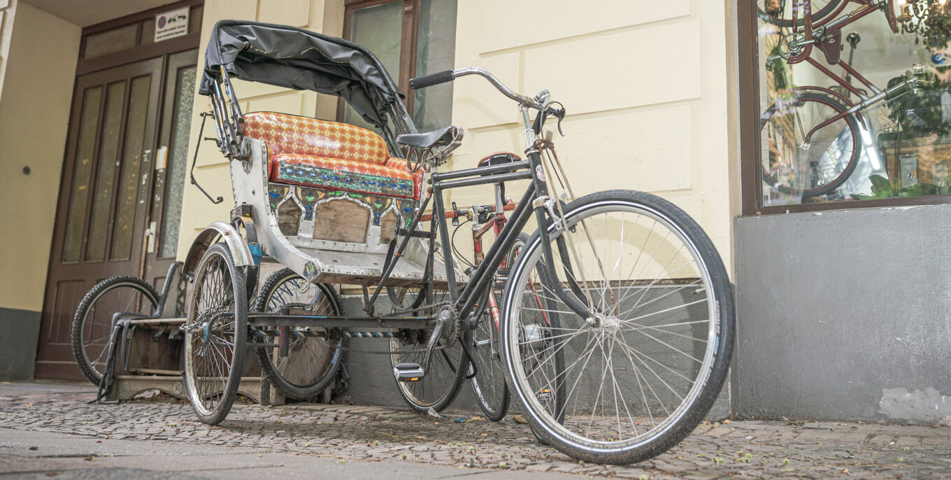 Eine Rikscha steht vor dem Fahrradladen Wulf.