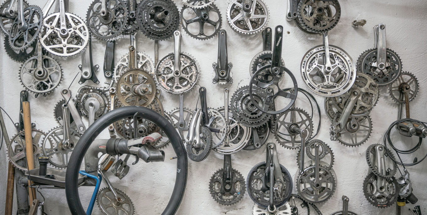 Diverse Teile für Fahrräder in verschiedenen Formen und Größen hängen an einer Wand.
