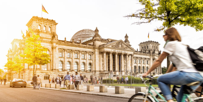 Frau fährt Fahrrad vor dem Reichstag