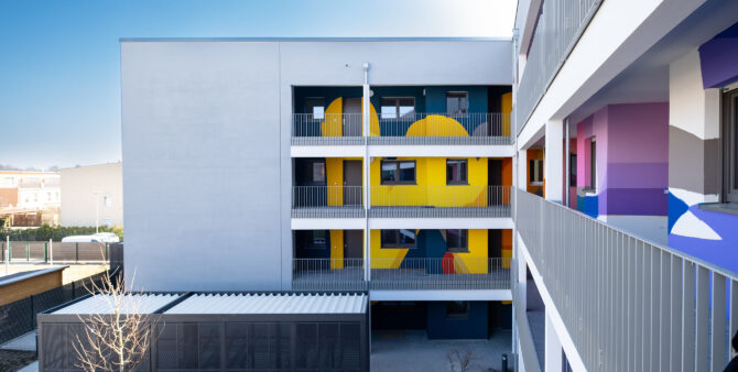 mit abstrakten Formen bunt bemalte Wände der Laubengänge in einem Neubau an der WATERKANT Berlin