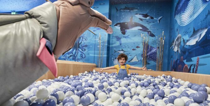 Ein Kind sitzt im Bällebad in der Ausstellung Anoha – Die Kinderwelt des Jüdischen Museums Berlin