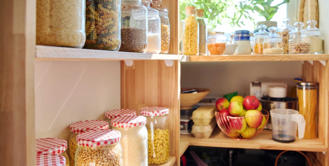 Lagerung von Lebensmitteln in der Küche in der Speisekammer. Müsli, Gewürze, Nudeln, Nüsse, Mehl in Gläsern und Behältern.