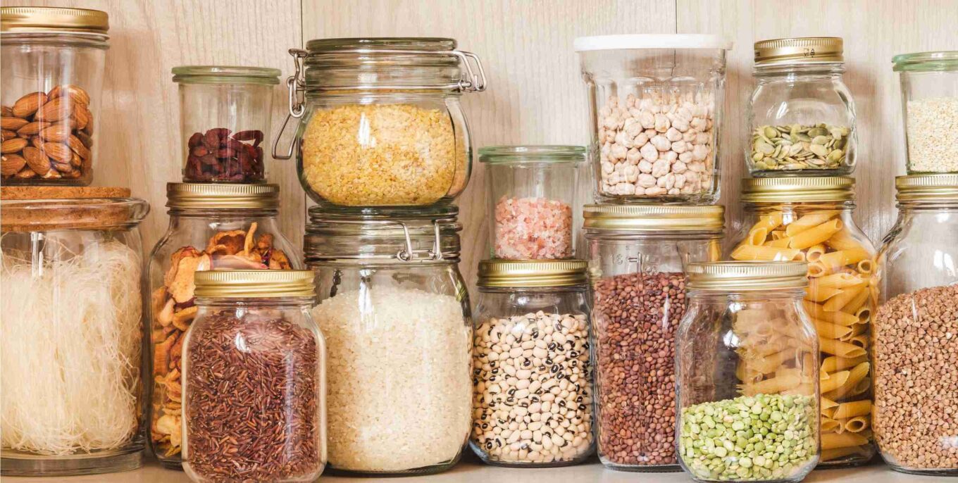 Lebensmittellagerung: Regal in einer Küche mit verschiedenen Getreidesorten und Samen in Aufbewahrungsgläsern.