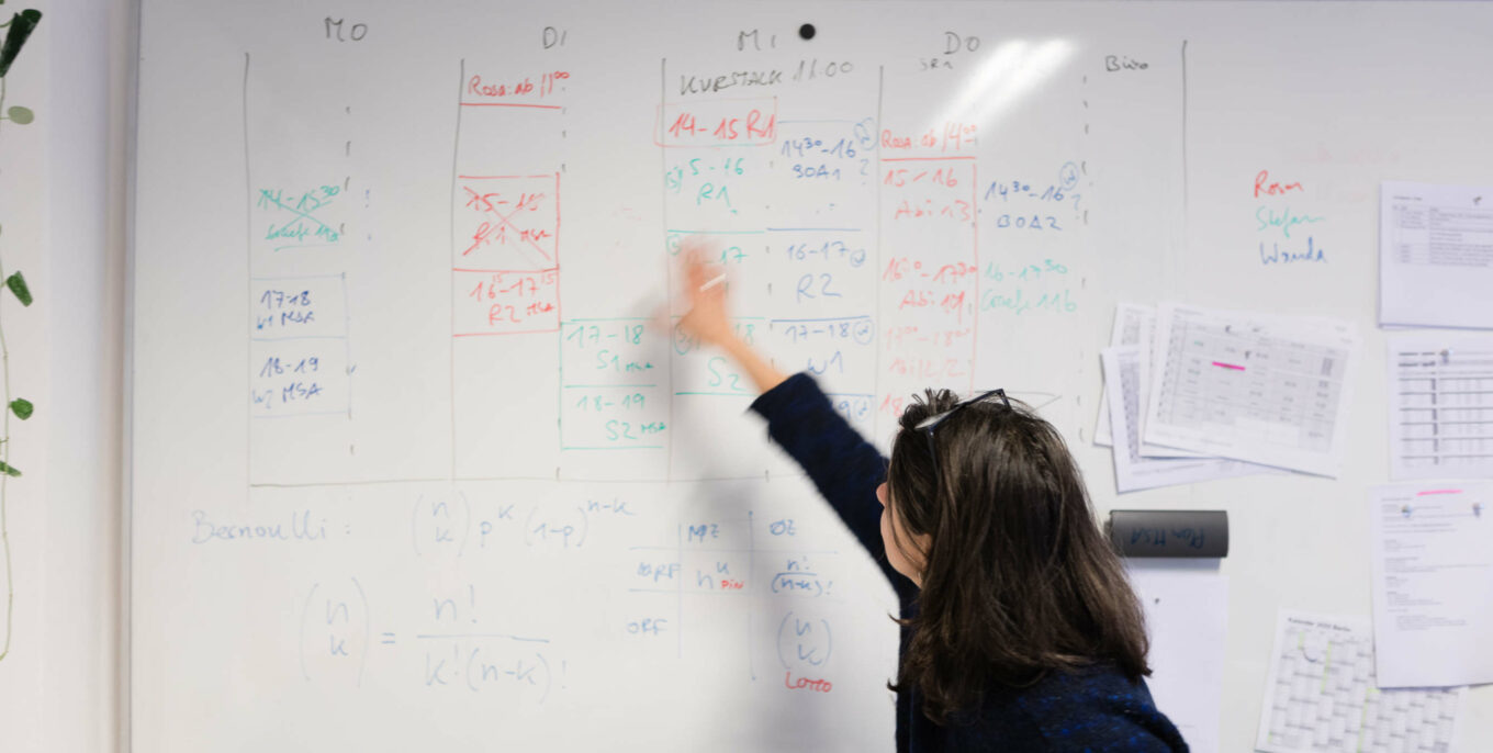 Eine Lehrerin zeigt an einem Whiteboard den Stundenplan von Plan MSA.