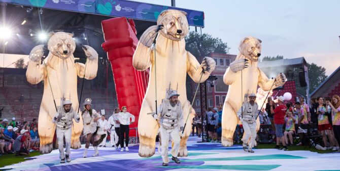 Special Olympics World Games: Bei der Eröffnungsfeier der National Games 2022 treten drei Künstler mit überdimensionalen Eisbär-Figuren auf ihren Rücken auf die Bühne.