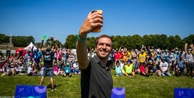 Special Olympics World Games: Fußball-Weltmeister Philipp Lahm macht während der National Games 2022 in Berlin ein Selfie. Im Hintergrund sind TeilnehmerInnen und BesucherInnen der Wettbewerbe zu sehen.