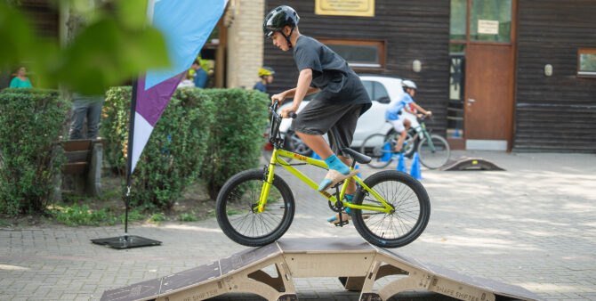 Ein Junge mit Helm fährt auf einem BMX-Fahrrad über eine Rampe vor dem Jugendclub Heckerdamm. Foto: Felix Seyfert.
