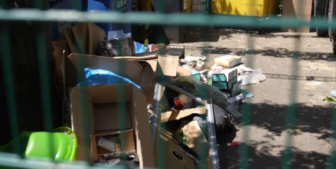Ein Müllplatz im Quartier Heerstraße Nord, in dem zahlreiche Kartons und anderer Müll vor Müllcontainern liegen. Foto: Screenshot aus dem Musikvideo Zero Waste Heroes / Staaken Version