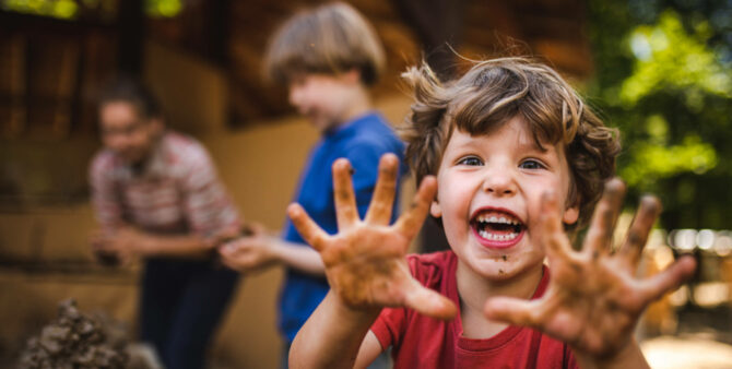 Kleiner Junge reckt seine schmutzigen Hände der Kamera entgegen. Foto: Britzer Garten / Konstantin Börner 
