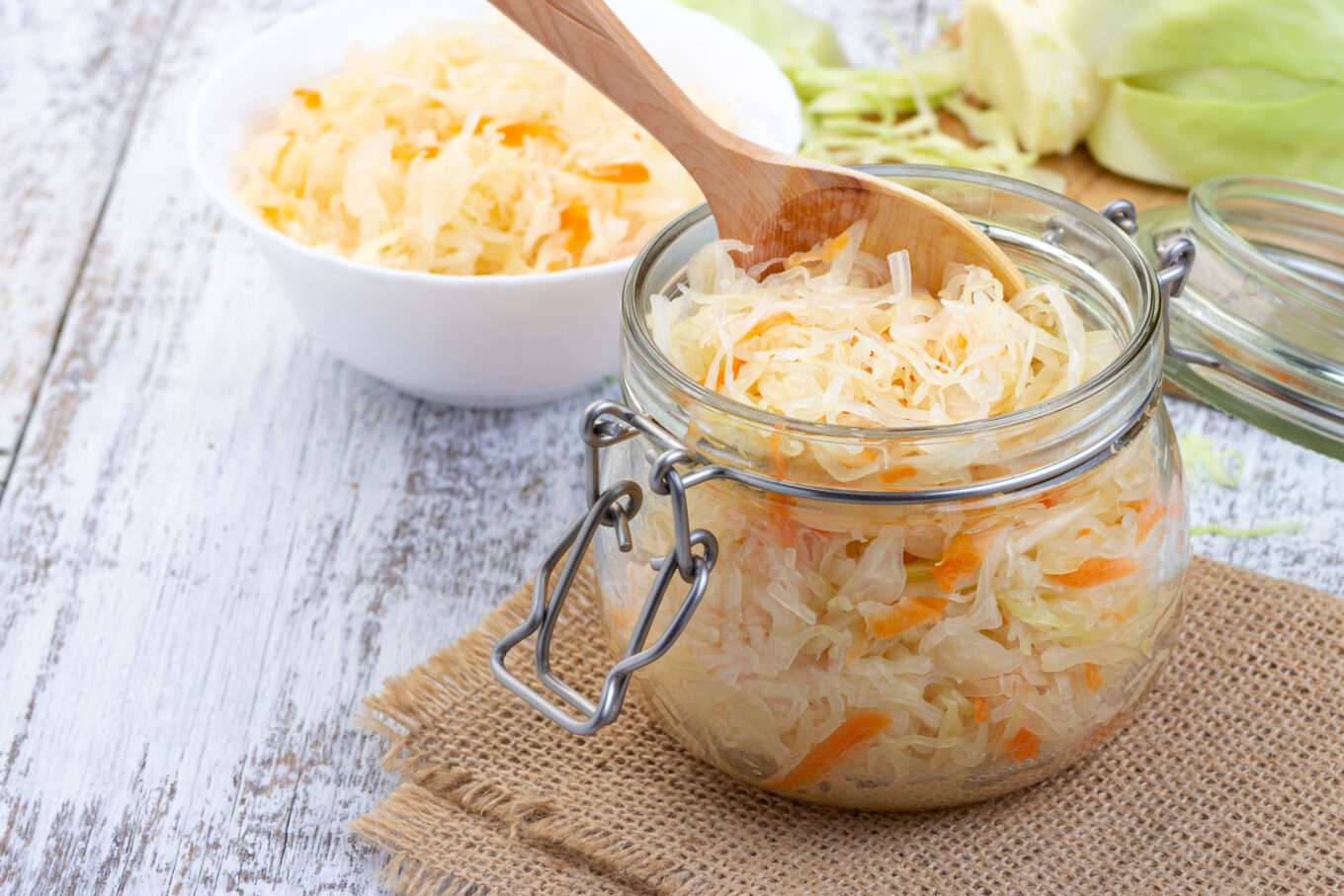 Ernährung bei Erkältung: Ein Glas mit frisch gemachtem Sauerkraut. Darin ist ein Holzlöffel platziert.