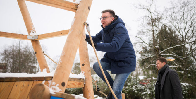 Spandaus Bezirksstadtrat Thorsten Schatz klettert auf ein schneebedecktes Spielplatzgerät. Foto: Moritz Eden/City-Press GmbH