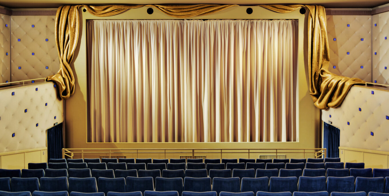 Das Filmtheater am Friedrichshain von innen: Der Kinosaal ist mit goldenem Stoff überzogen, die Sitze samtig dunkelblau.