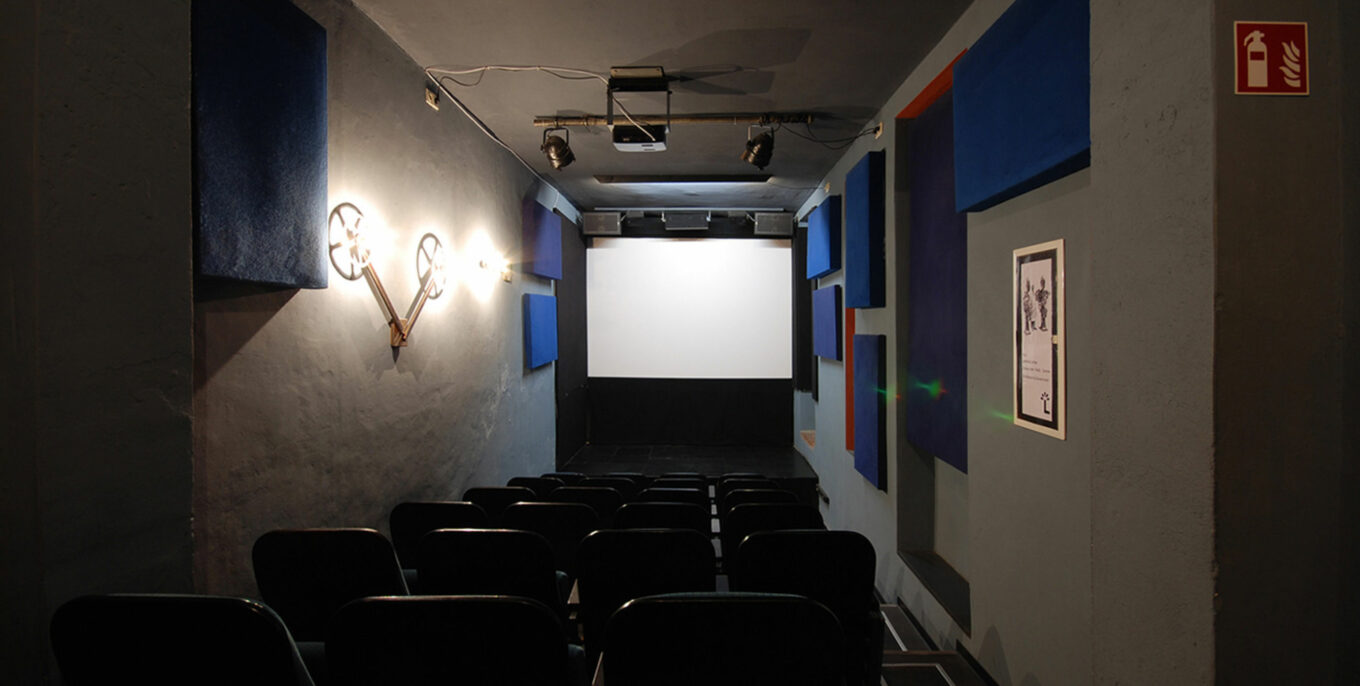 Das Lichtblick Kino von innen: wenige Sitzplätze, davor eine kleine Leinwand.