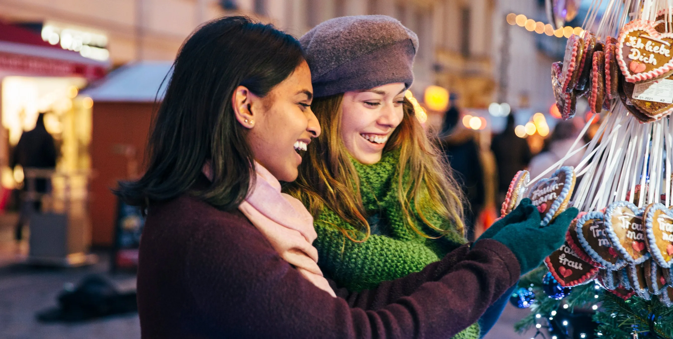 Zwei Frauen schauen sich auf dem Weihnachtsmarkt Lebkuchen an.