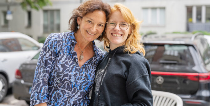 Zwei Frauen stehen eng beieinander und umarmen sich leicht, während sie in die Kamera lächeln. Foto: Felix Seyfert