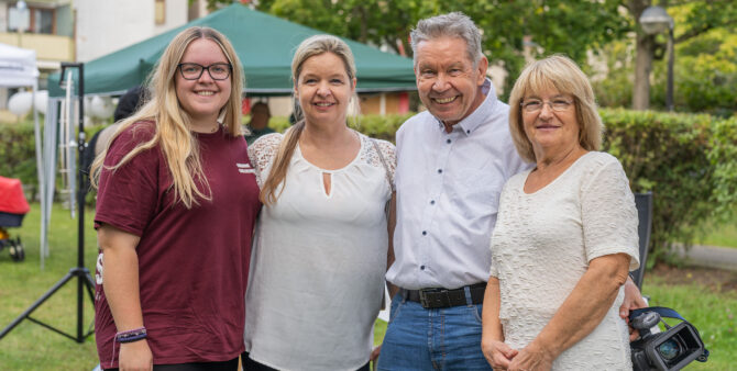 Vier Personen posieren gemeinsam vor einem grünen Pavillon bei einer Outdoor-Veranstaltung. Foto: Felix Seyfert