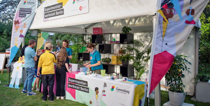Ein Aktionsstand der Gewobag bei einem Quartiersfest. Auf einem Schild ist "Experimentierwerkstatt Berlin" zu lesen. Foto: Jennifer Sanchez