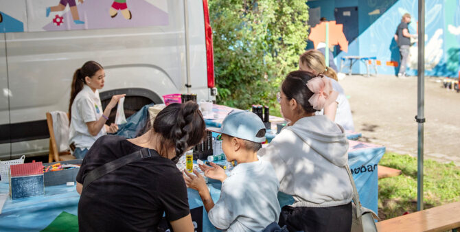 Drei Kinder und zwei Frauen an einer Bastelstation bei einem Quartiersfest. Foto: Jennifer Sanchez