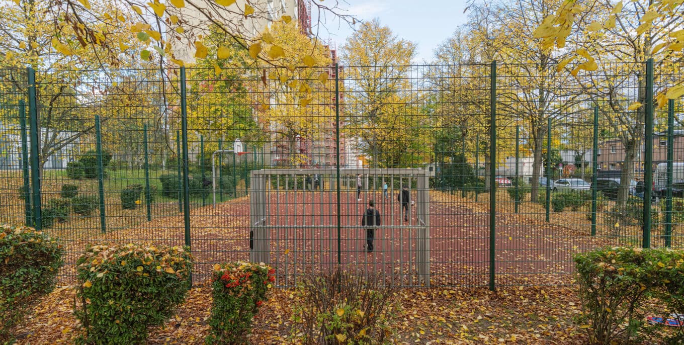Aufnahme aus der Hintertor-Perspektive: Kinder in einem Fußballkäfig, auf dem Herbstlaub liegt. Foto: Felix Seyfert