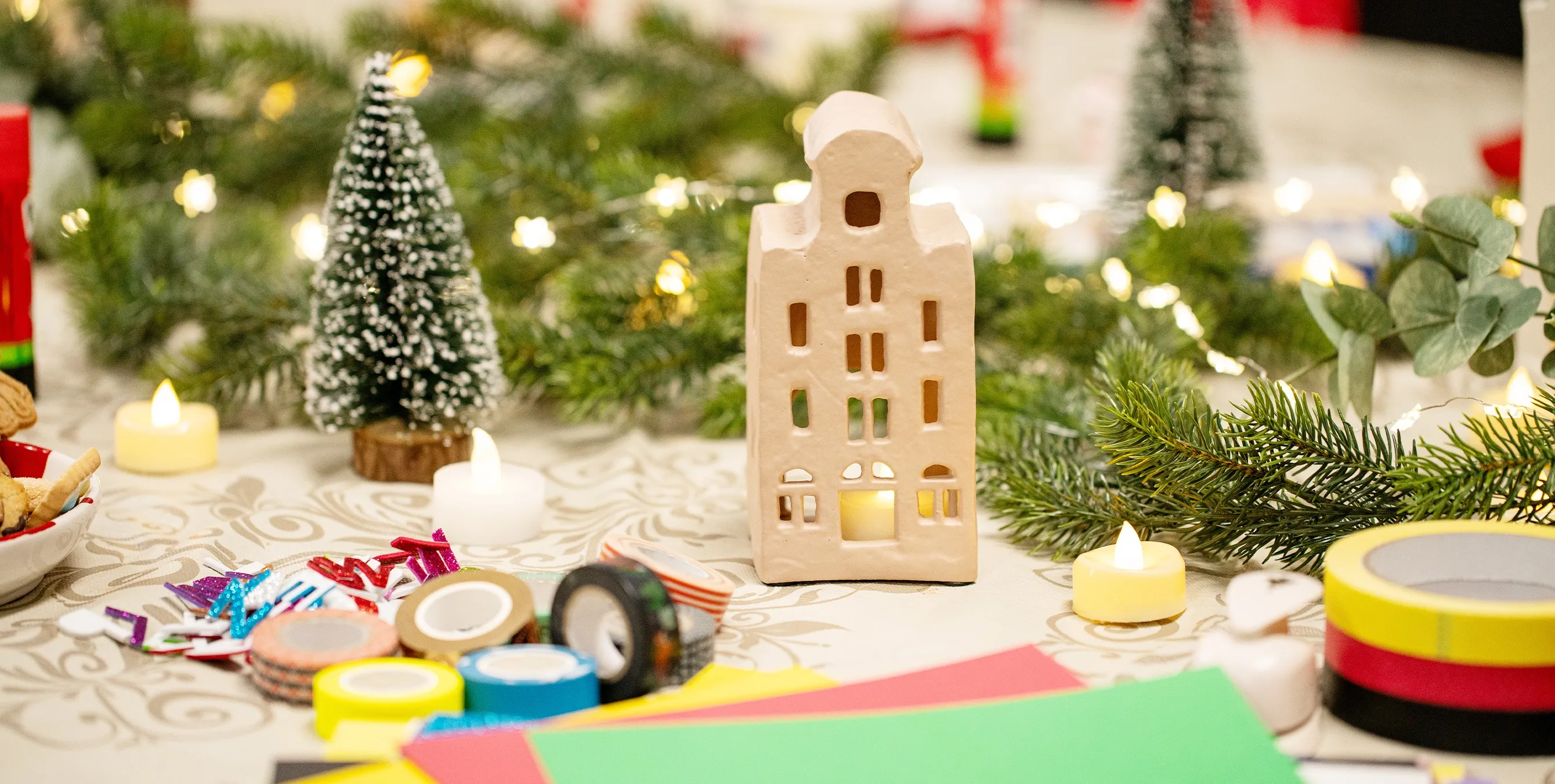 Großaufnahme: ein weihnachtlich dekorierter Tisch mit buntem Papier und bunten Klebebandrollen. Foto: Ralph Maak