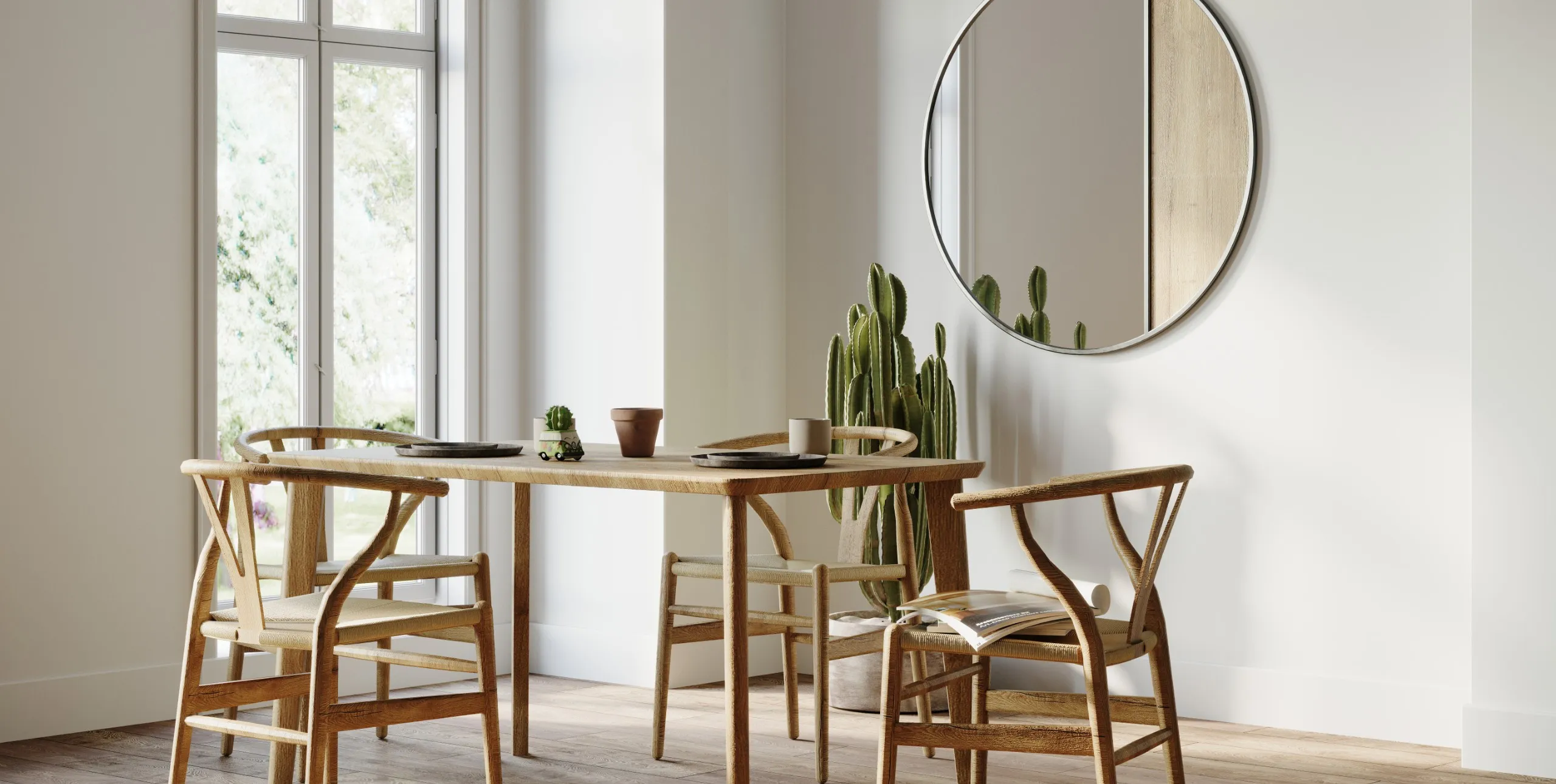 Modern eingerichtetes Esszimmer mit hellem Holztisch, passenden Stühlen, großem Kaktus und rundem Spiegel