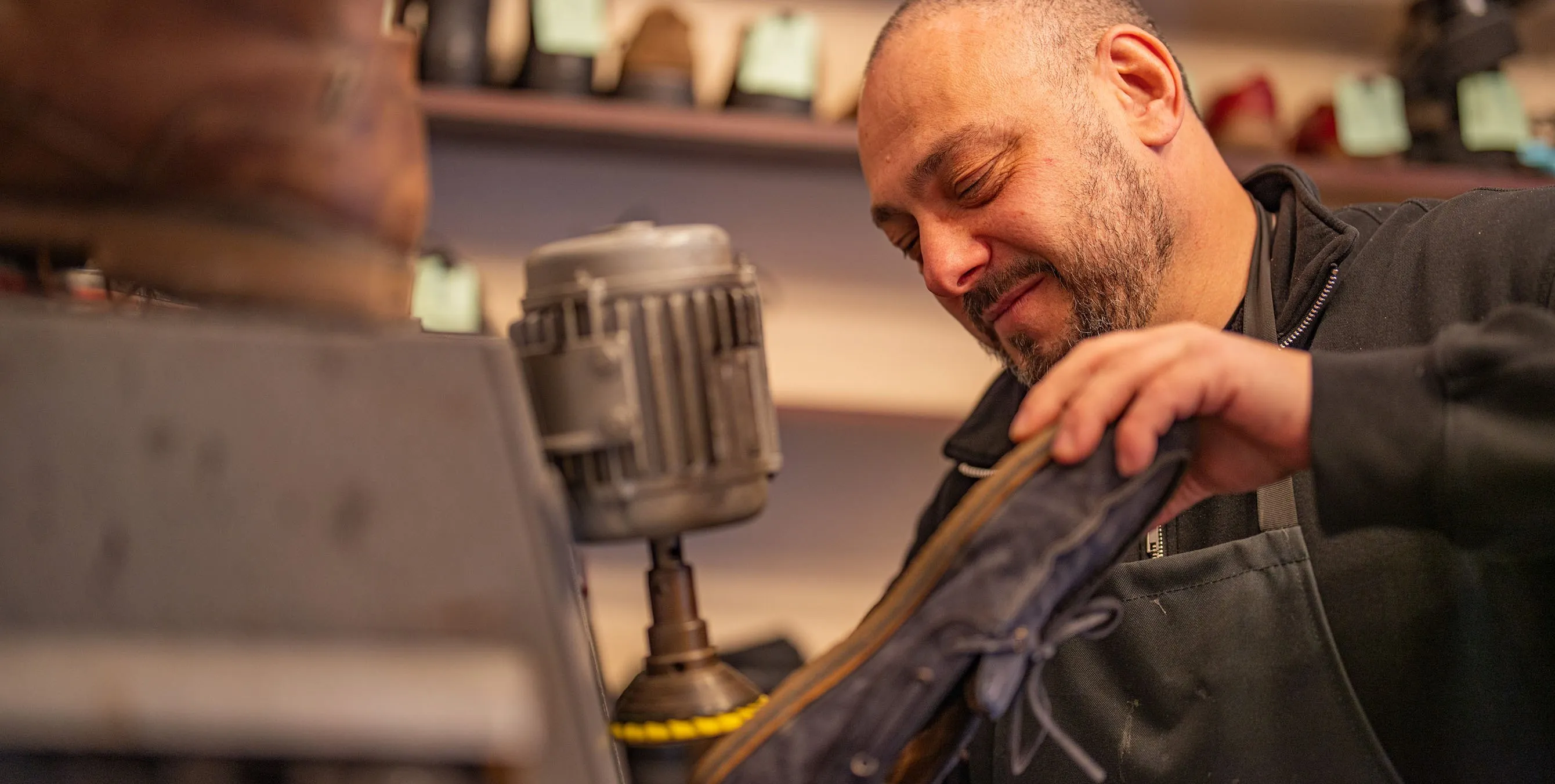 Großaufnahme: Ein Schuhmacher bearbeitet die Sohle eines Schuhs an einer speziellen Maschine. Foto: Felix Seyfert