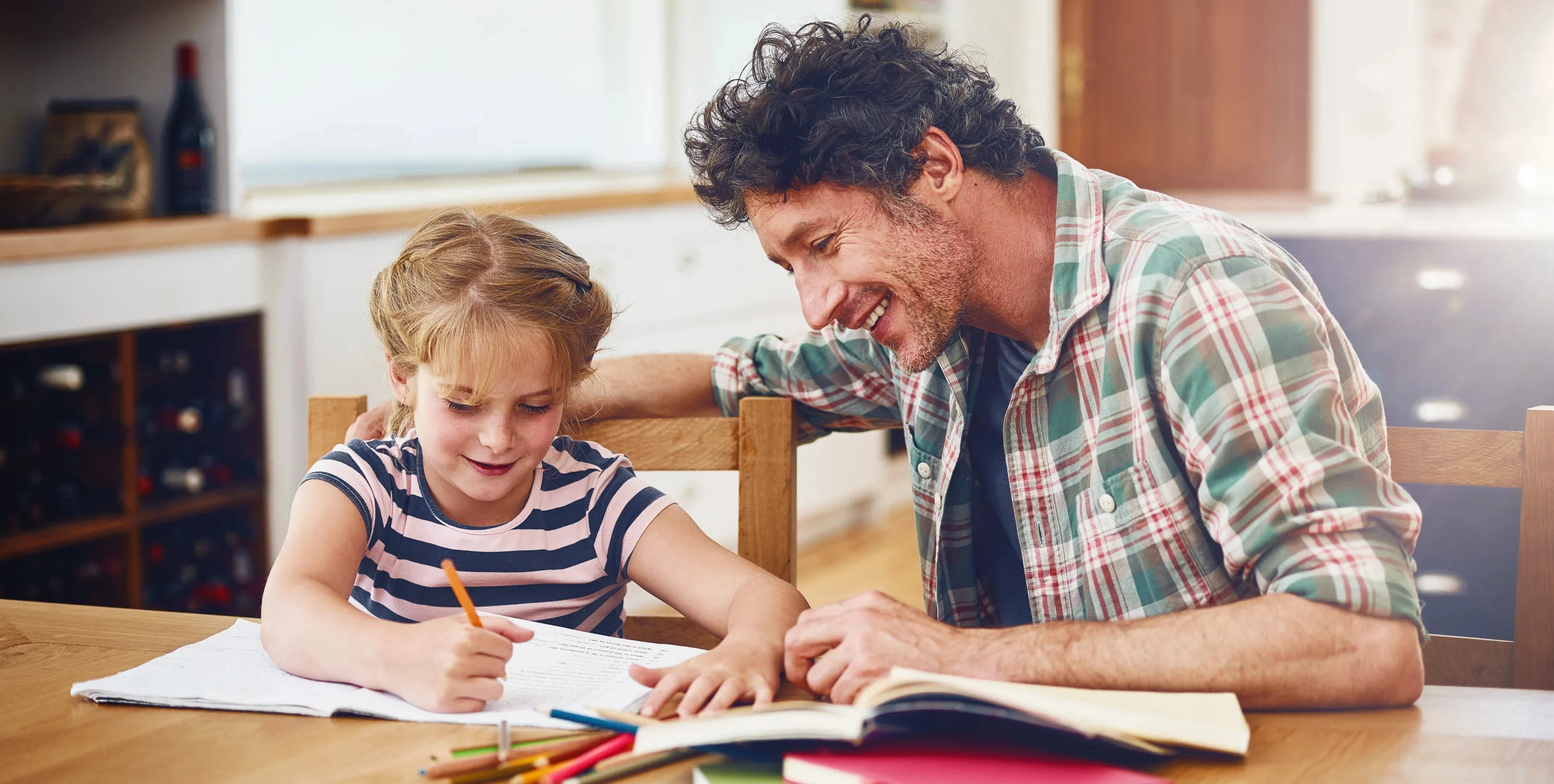 Ein Vater hilft seiner Tochter bei den Hausaufgaben.