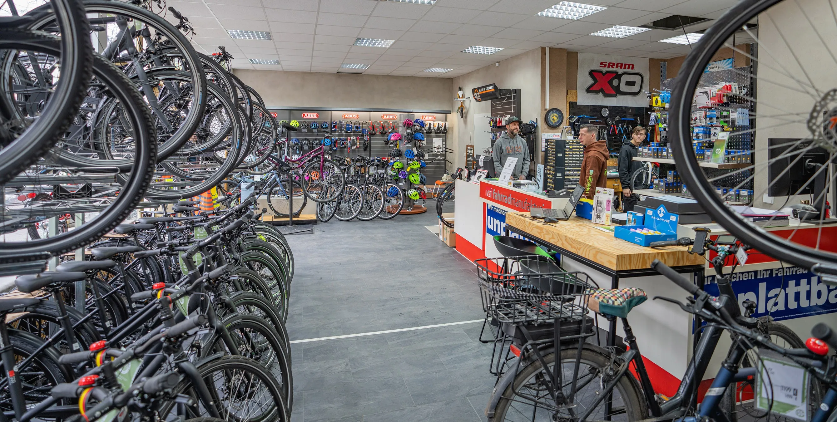 Blick in ein Fahrradgeschäft: zahlreiche aufgereihte Räder, eine mit Helmen und Schlössern bestückte Wand, ein Verkaufstresen und verschiedene Werbebanner. Foto: Felix Seyfert