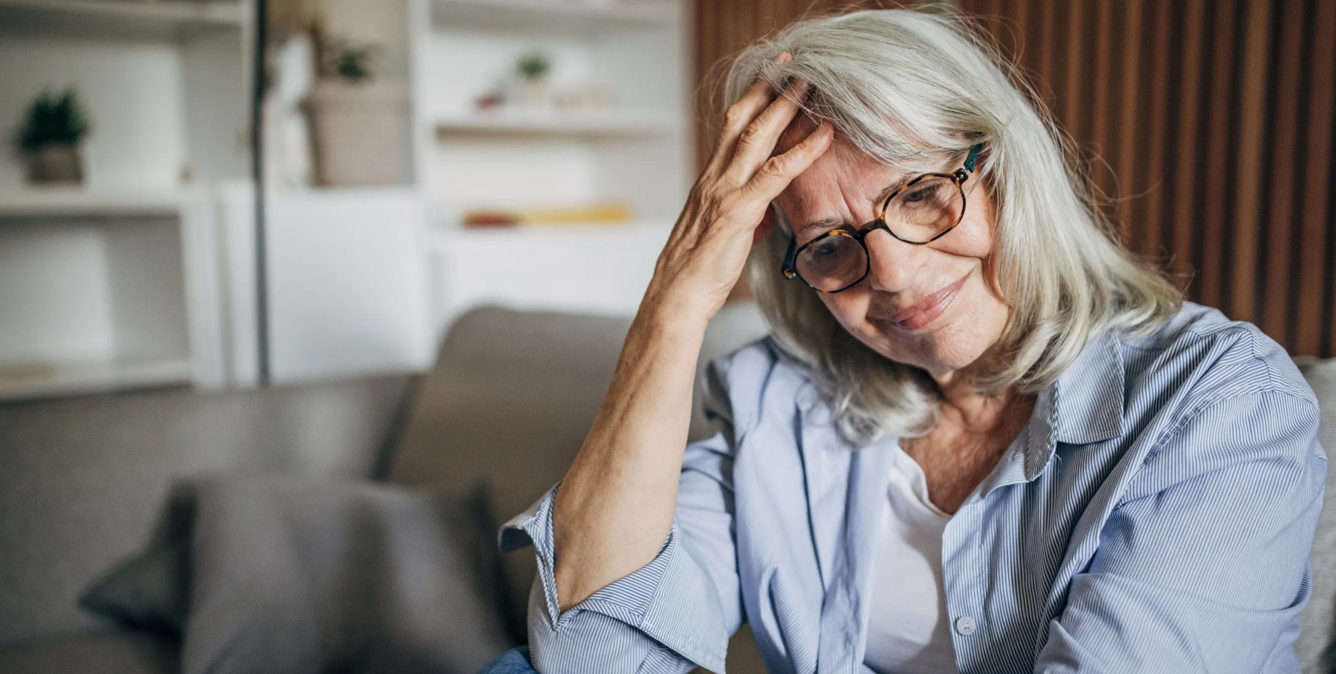 nachdenkliche, melancholische Frau mit grauen Haaren