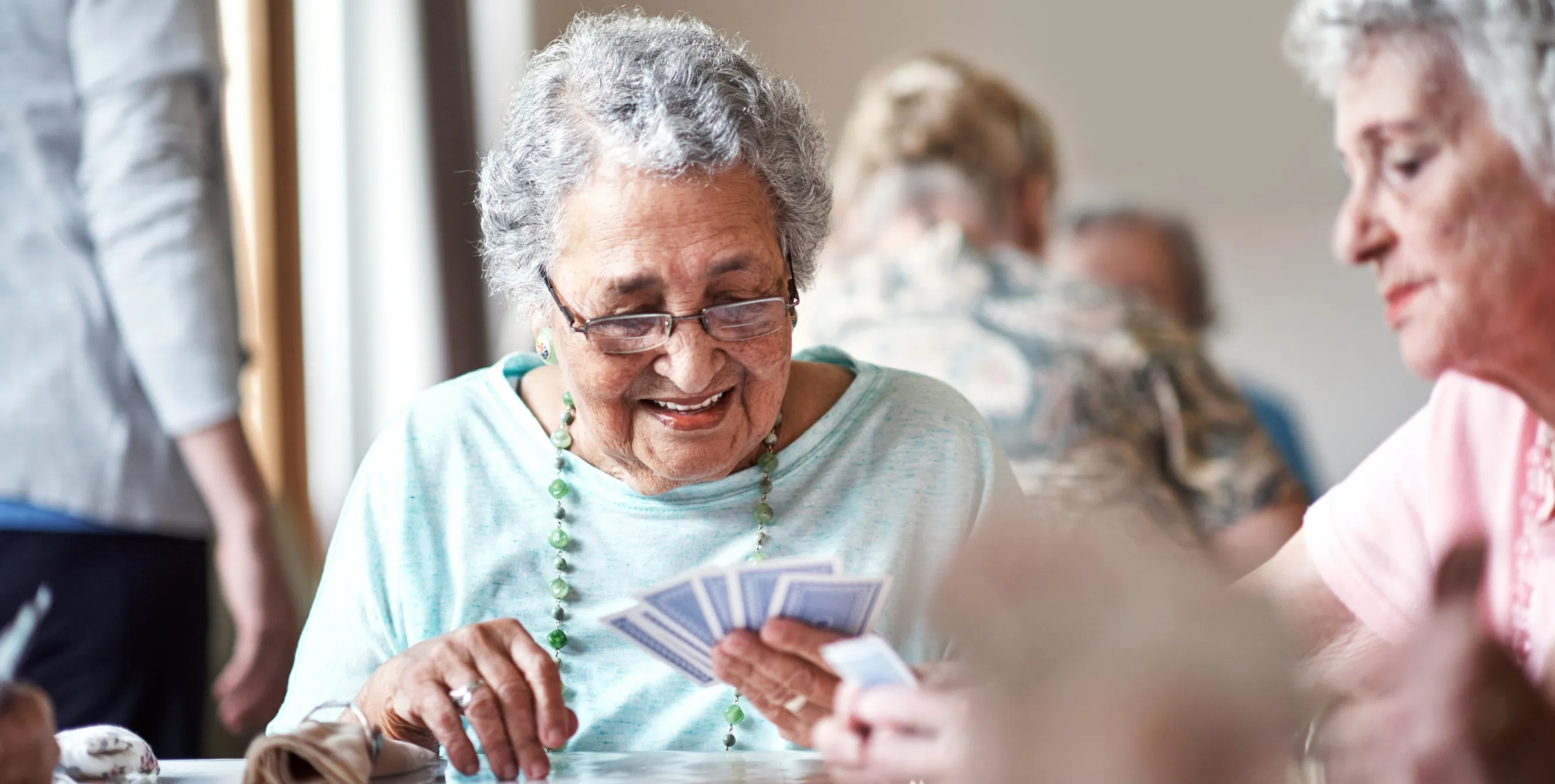 Zwei ältere Damen spielen Karten in einem Nachbarschaftstreff