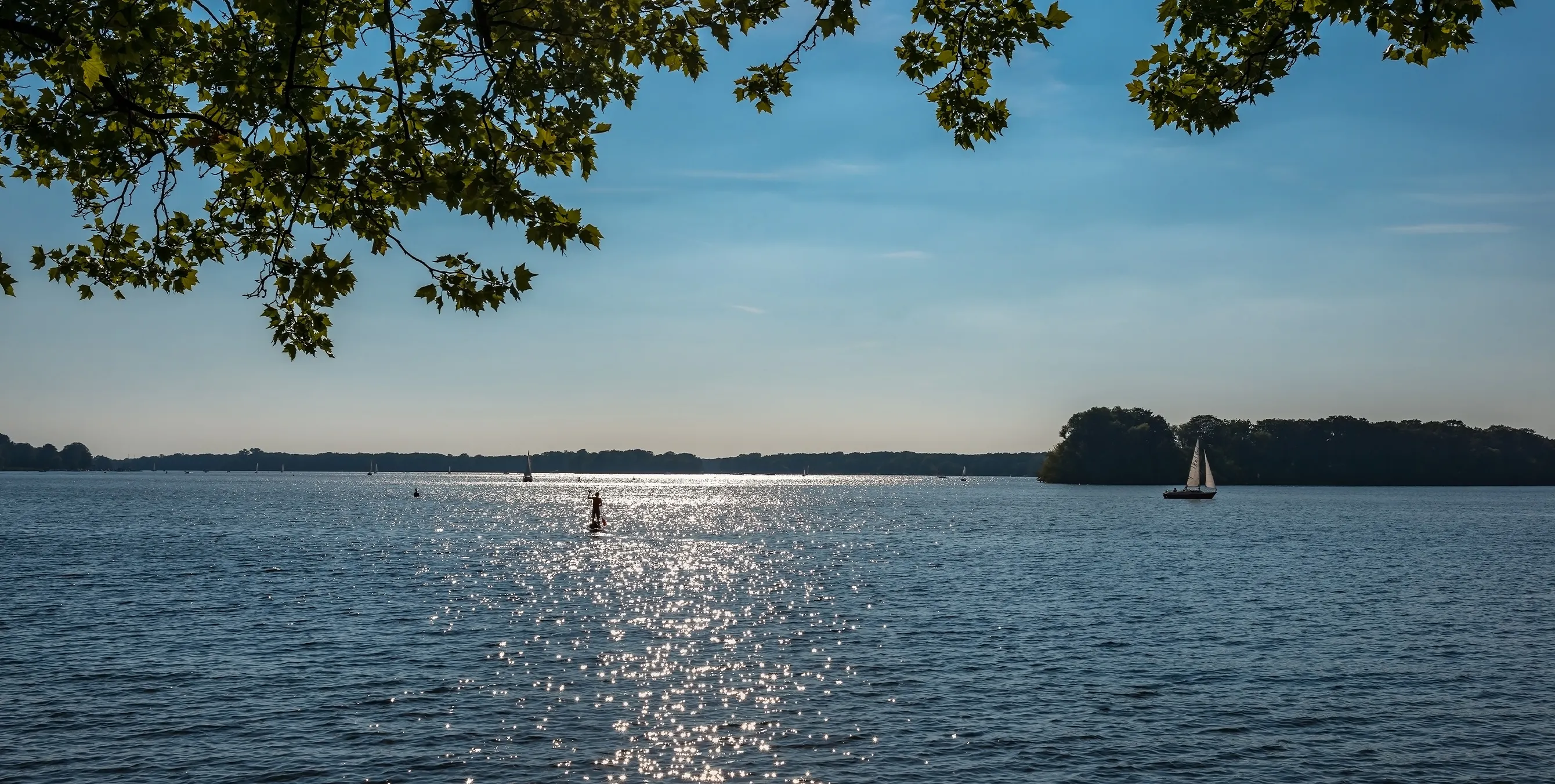 Surfer auf dem Tegeler See bei Berlin bei Sonnenschein und blauem Himmel