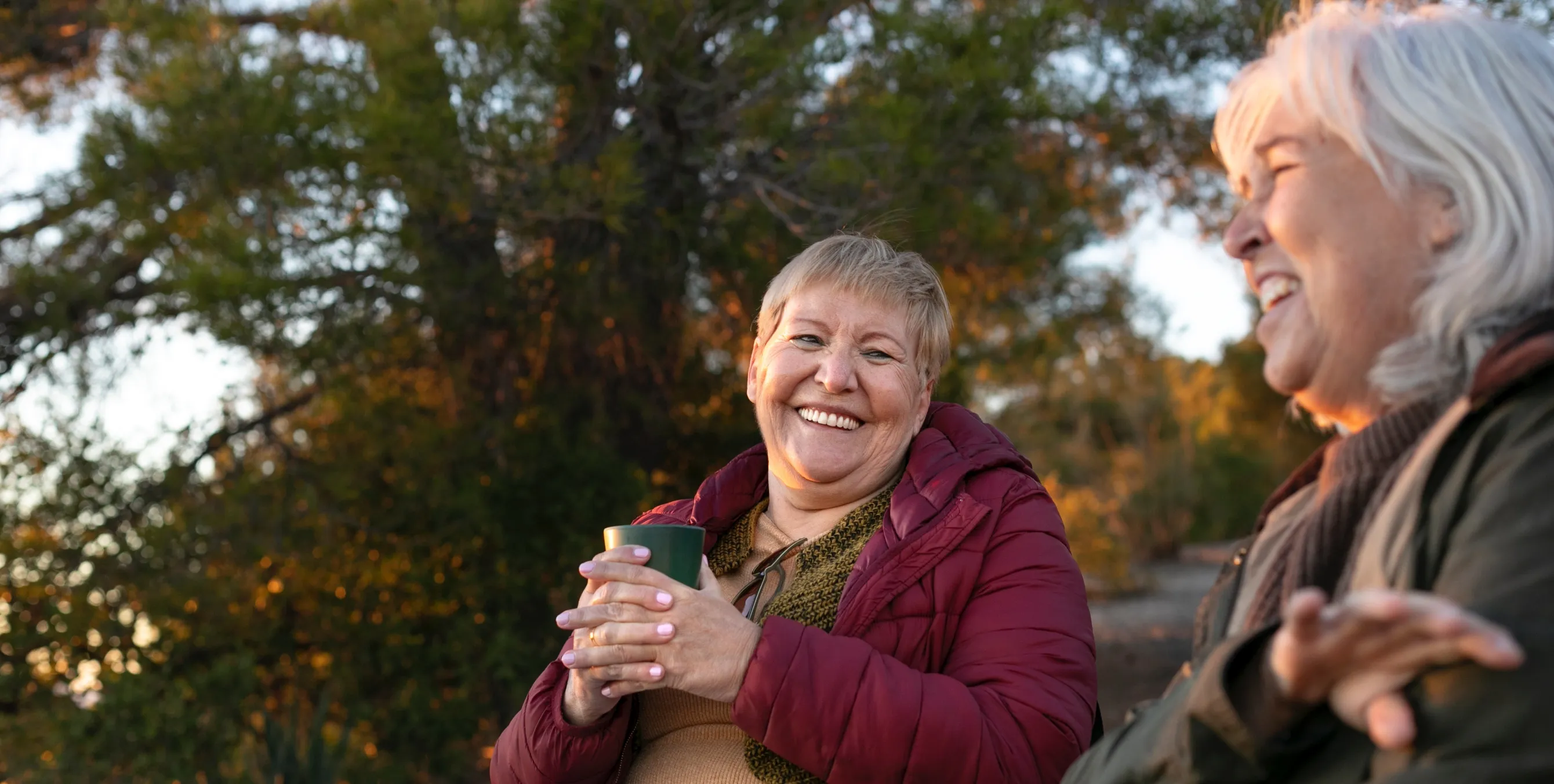 Zwei ältere Damen, die sich auf einer PArkbank sitzend unterhalten