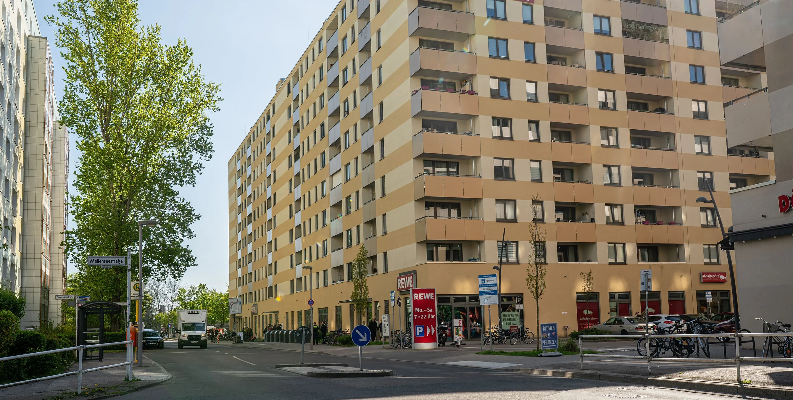 Ein Hochhaus mit vielen Balkonen und einer gelben Fassade an einer Straße. Im Erdgeschoss ist ein Supermarkt zu erkennen. Foto: Ralph Maak