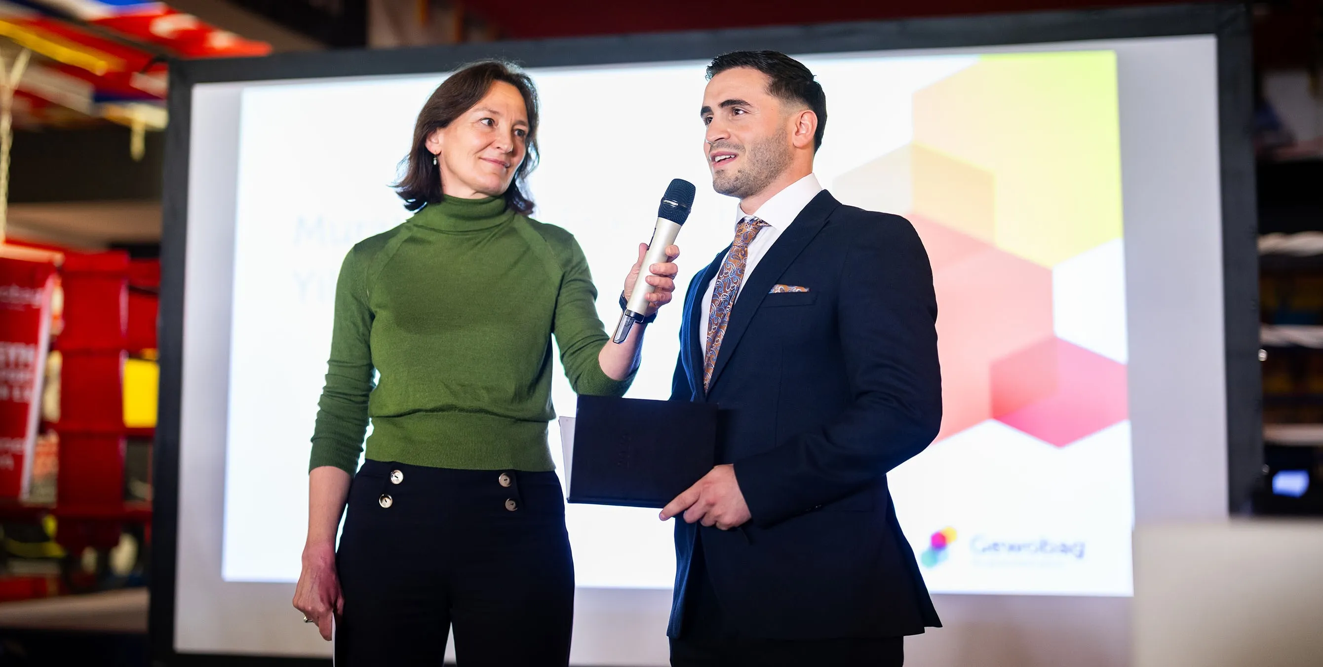 Eine Moderatorin hält einem jungen Mann im Anzug ein Mikrofon hin. Der junge Mann hält eine Rede. Foto: City-Press GmbH