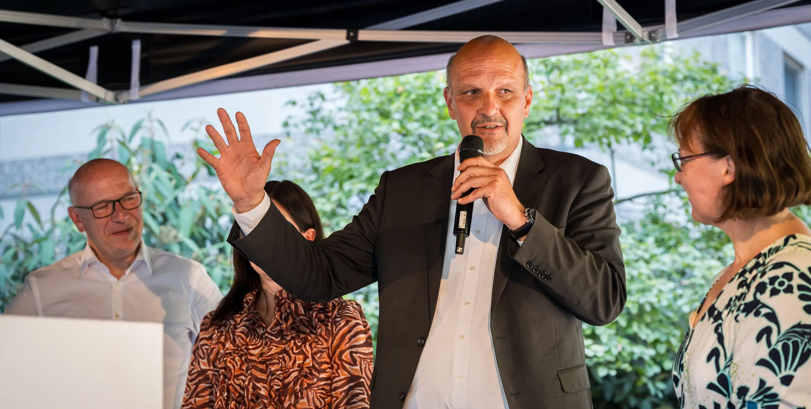 Ein Mann steht auf einer Bühne im Freien und spricht in ein Mikrofon. Foto: City-Press GmbH