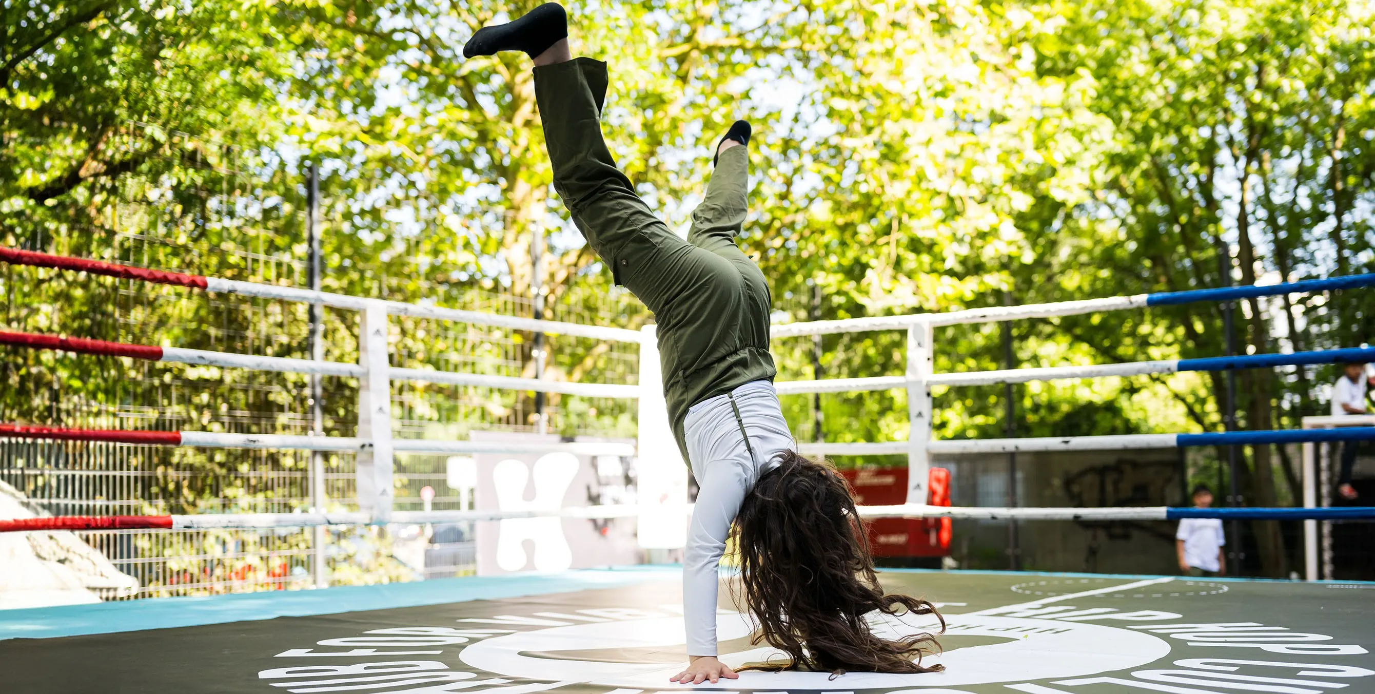 Szene von einem Quartiersfest: Ein junges Mädchen macht bei einer Breakdance-Show eine Art Handstand. Foto: City-Press GmbH