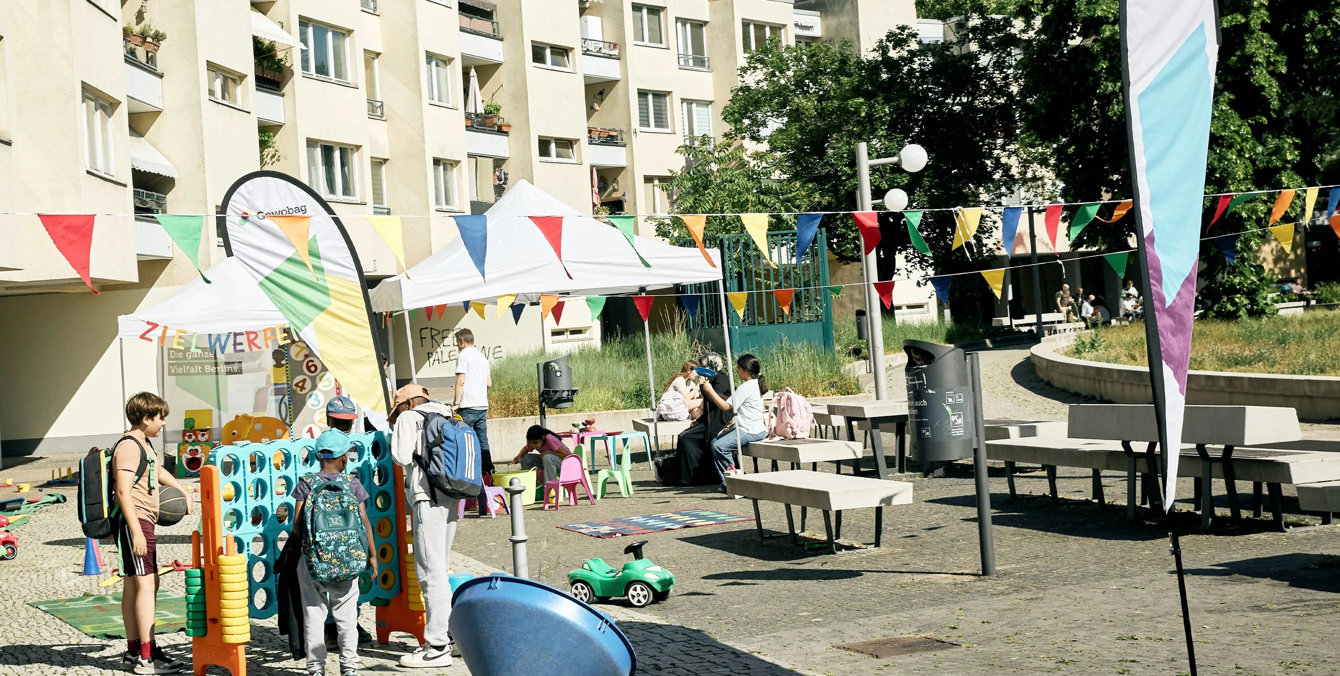 Szene auf einem öffentlichen Platz: Ein paar Kinder an Spielstationen unter Wimpelketten. Foto: Britta Leuermann