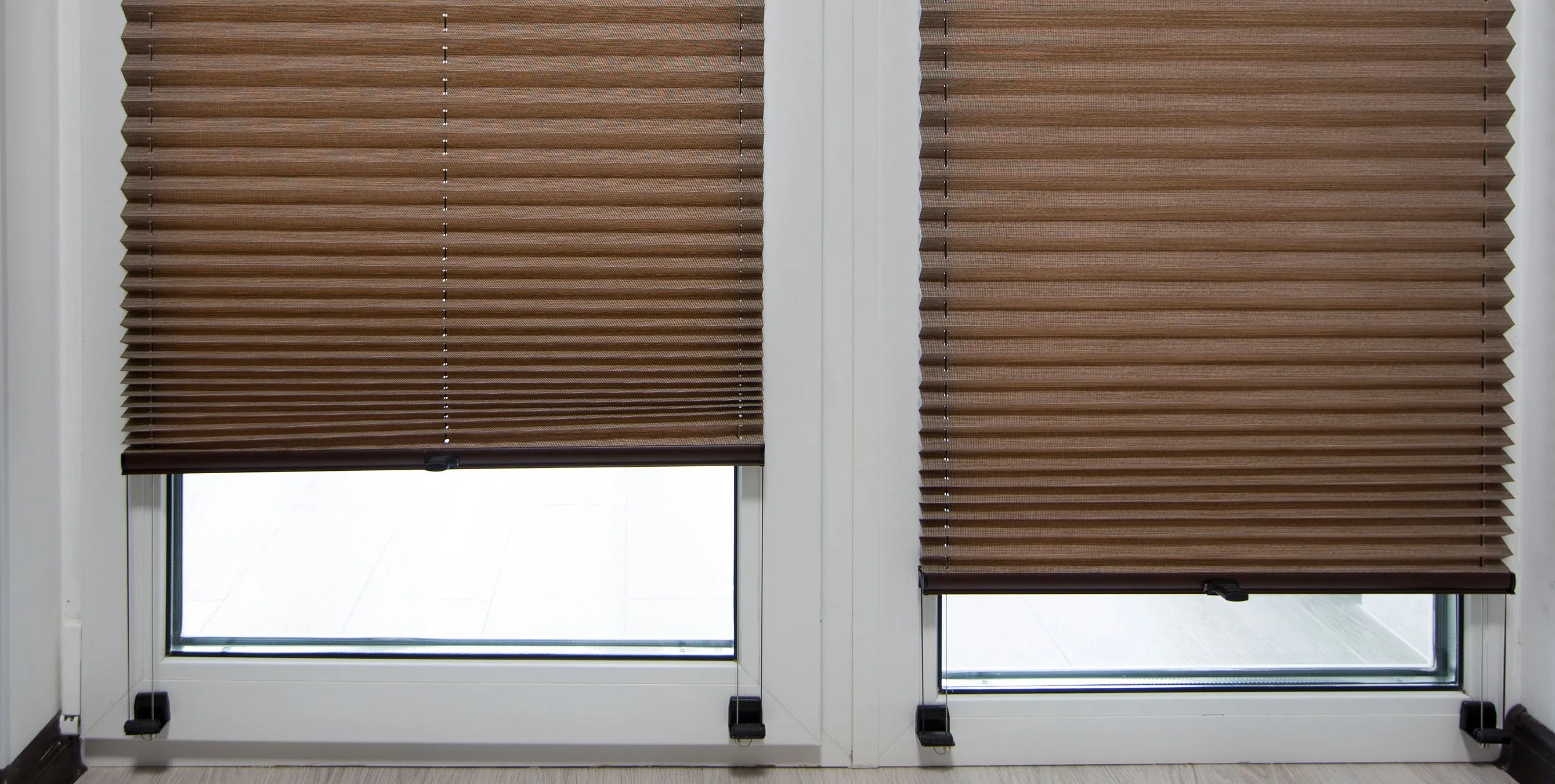 Zwei Fenster mit fast komplett heruntergelassenen Plissees. Foto: iStock