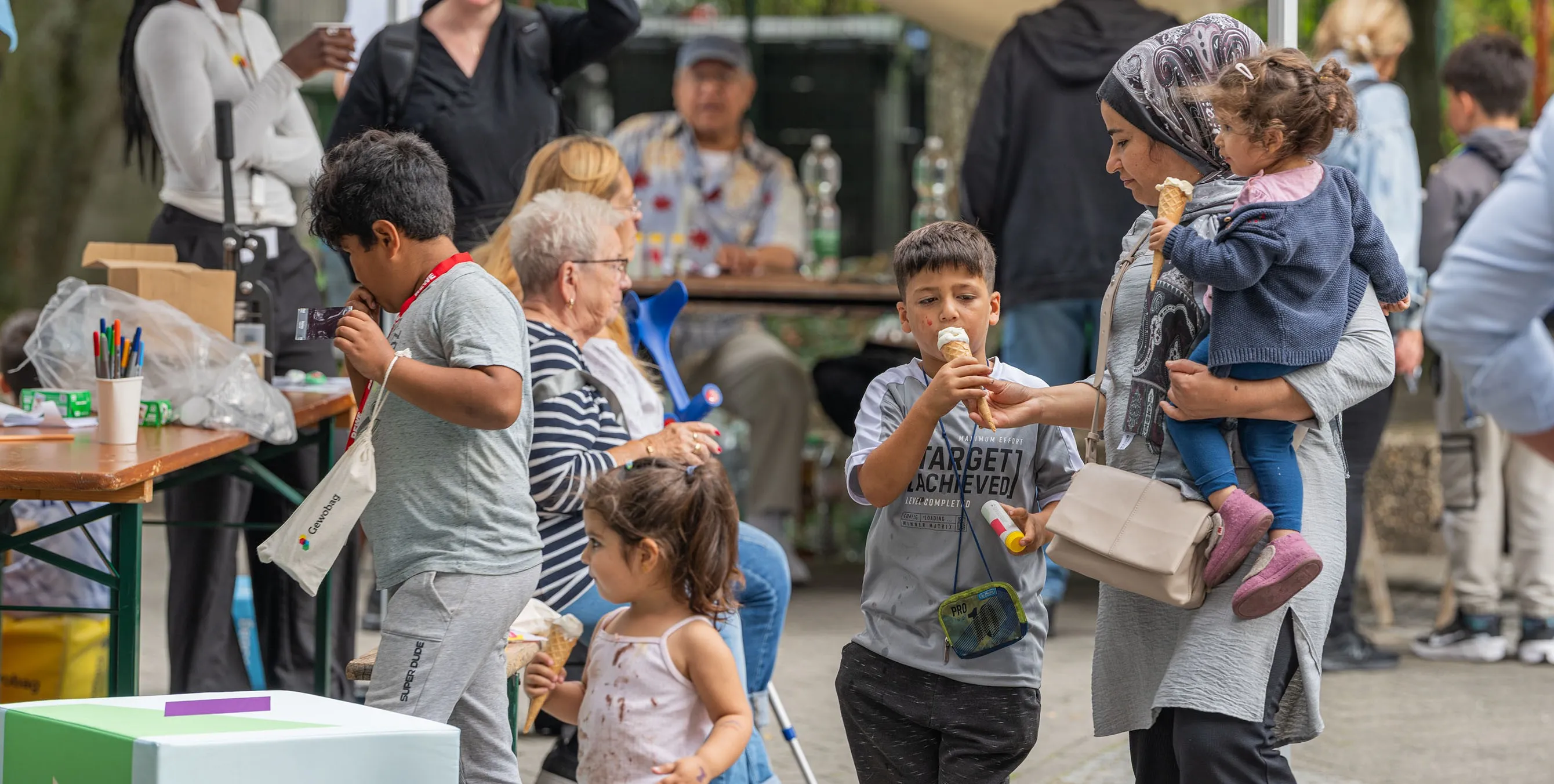 Szene von einem Quartierfest im Freien: Kinder und Erwachse an Ständen zum Teil mit Eis in der Hand. Foto: Felix Seyfert
