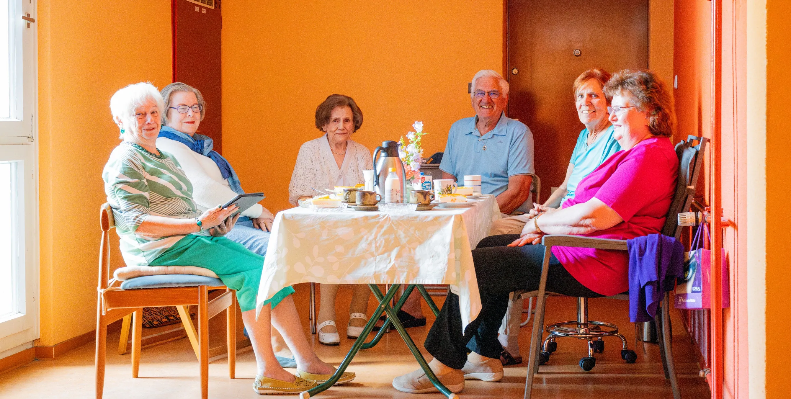 Mietertreff im Treppenhaus an einer Kaffeetafel.