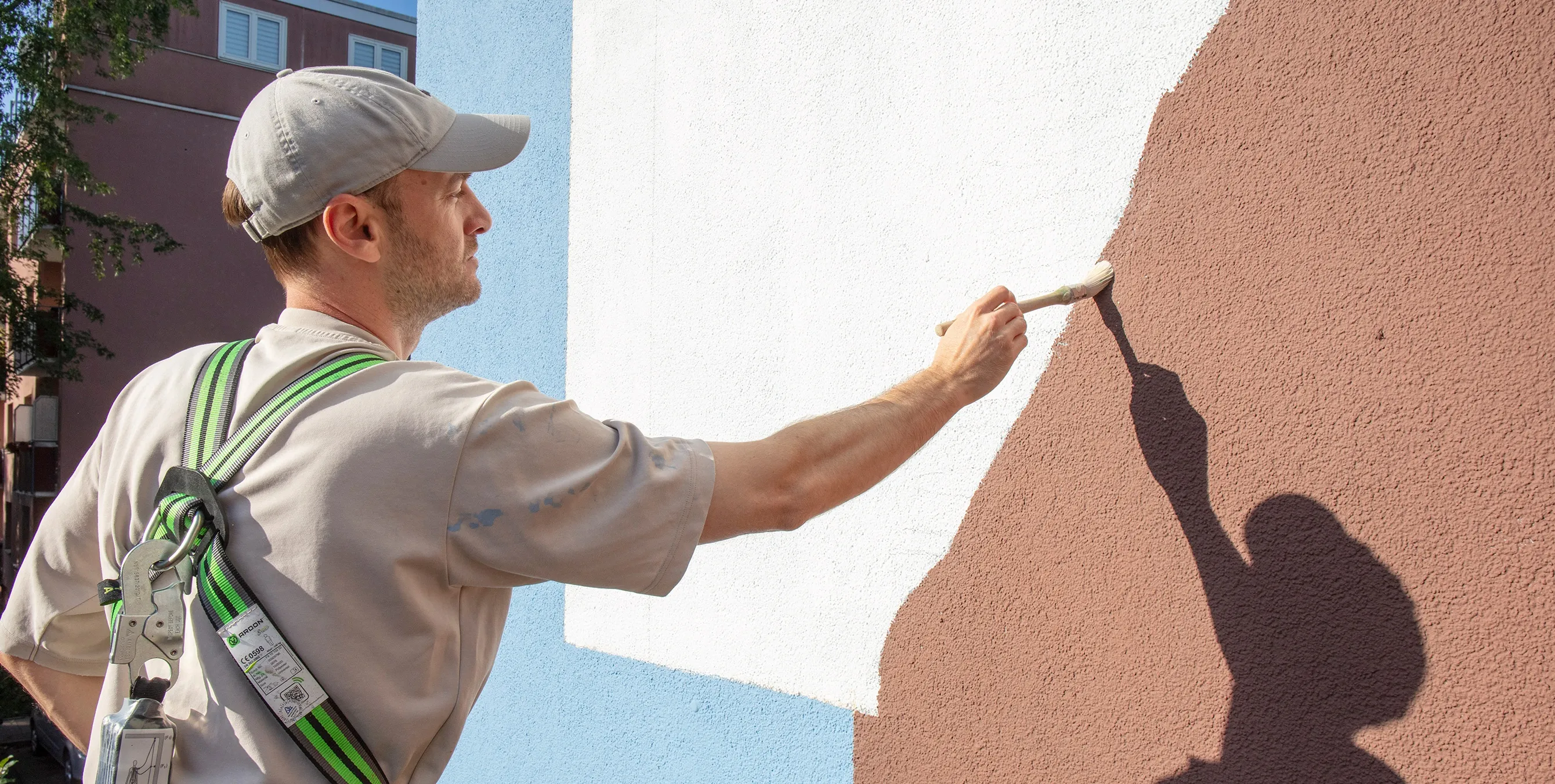 Ein Mann bemalt eine Wand mit einem Pinsel. Foto: Ludger Paffrath